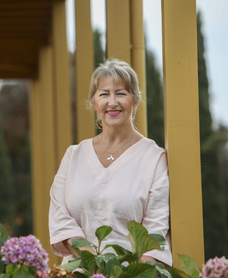 A woman standing in front of some flowers.