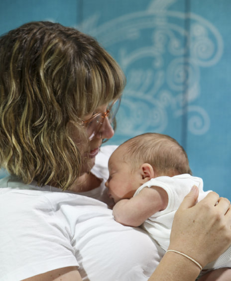 A woman holding a baby in her arms.