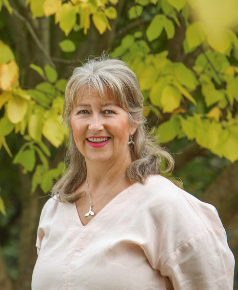 A woman standing in front of some trees