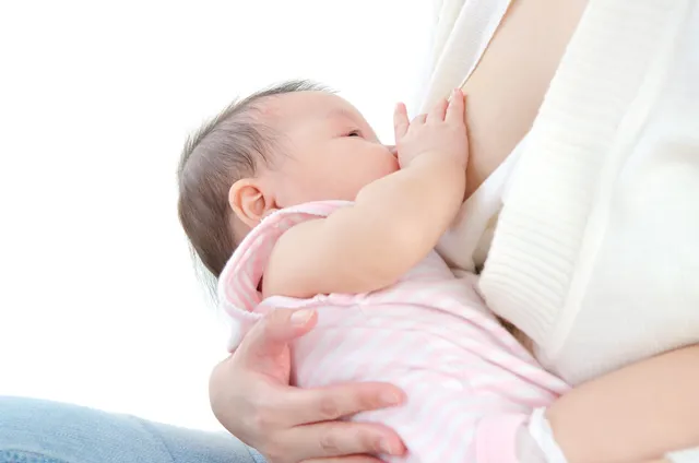 A woman is holding her baby in the air