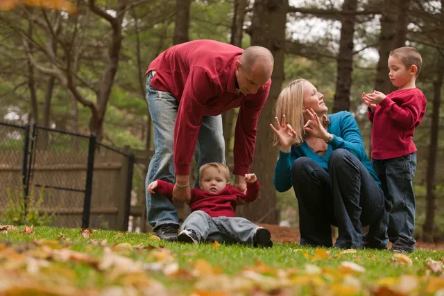 A man and woman watch as a child plays with an adult.