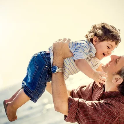 A man holding his son in the air.